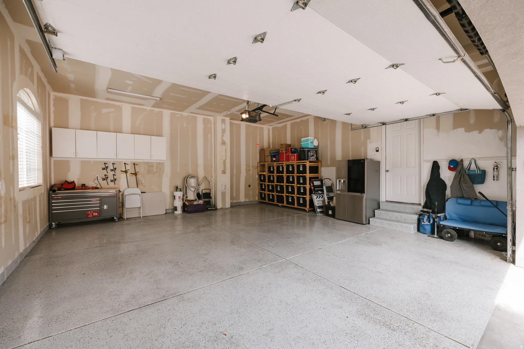 Garage featuring stainless steel fridge with ice dispenser