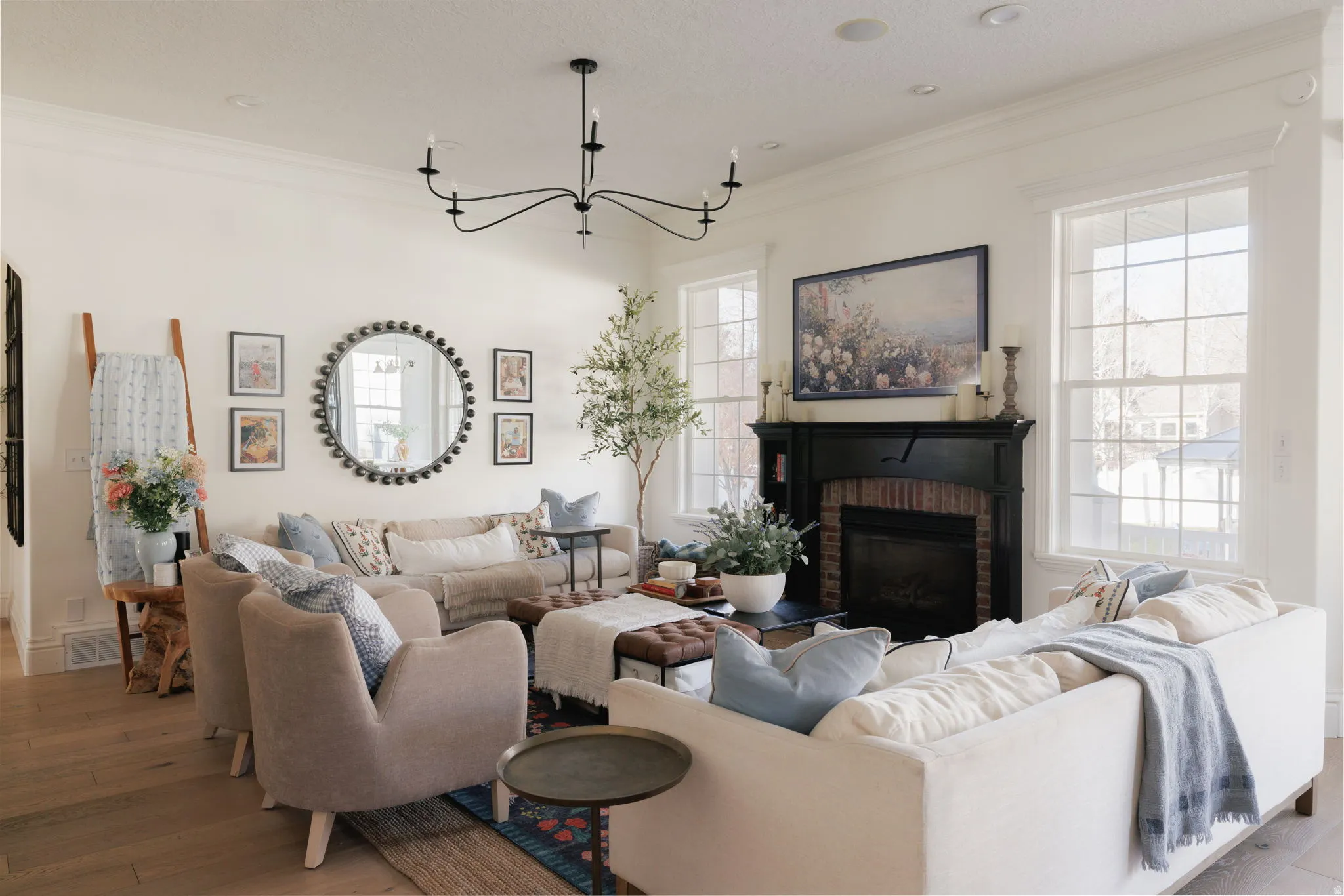 Living room with hardwood / wood-style flooring, ornamental molding, a fireplace, and a chandelier