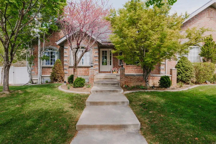 View of front facade featuring brick siding, a front lawn, and a gate