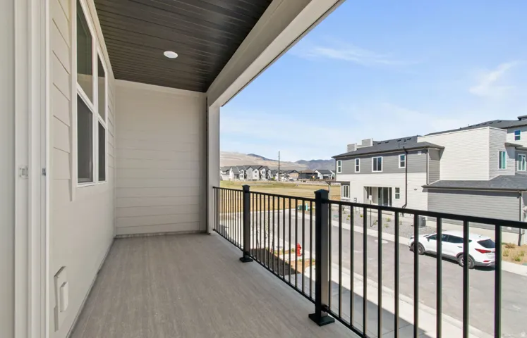 Covered balcony with composite decking and black metal railing