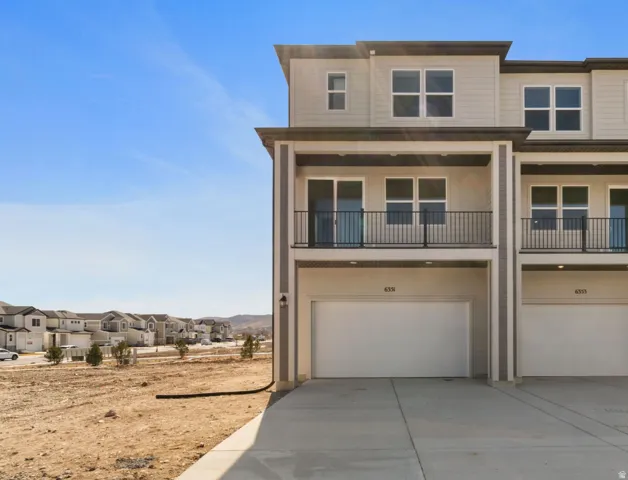 Modern multi-level exterior featuring light-colored siding and dark trim