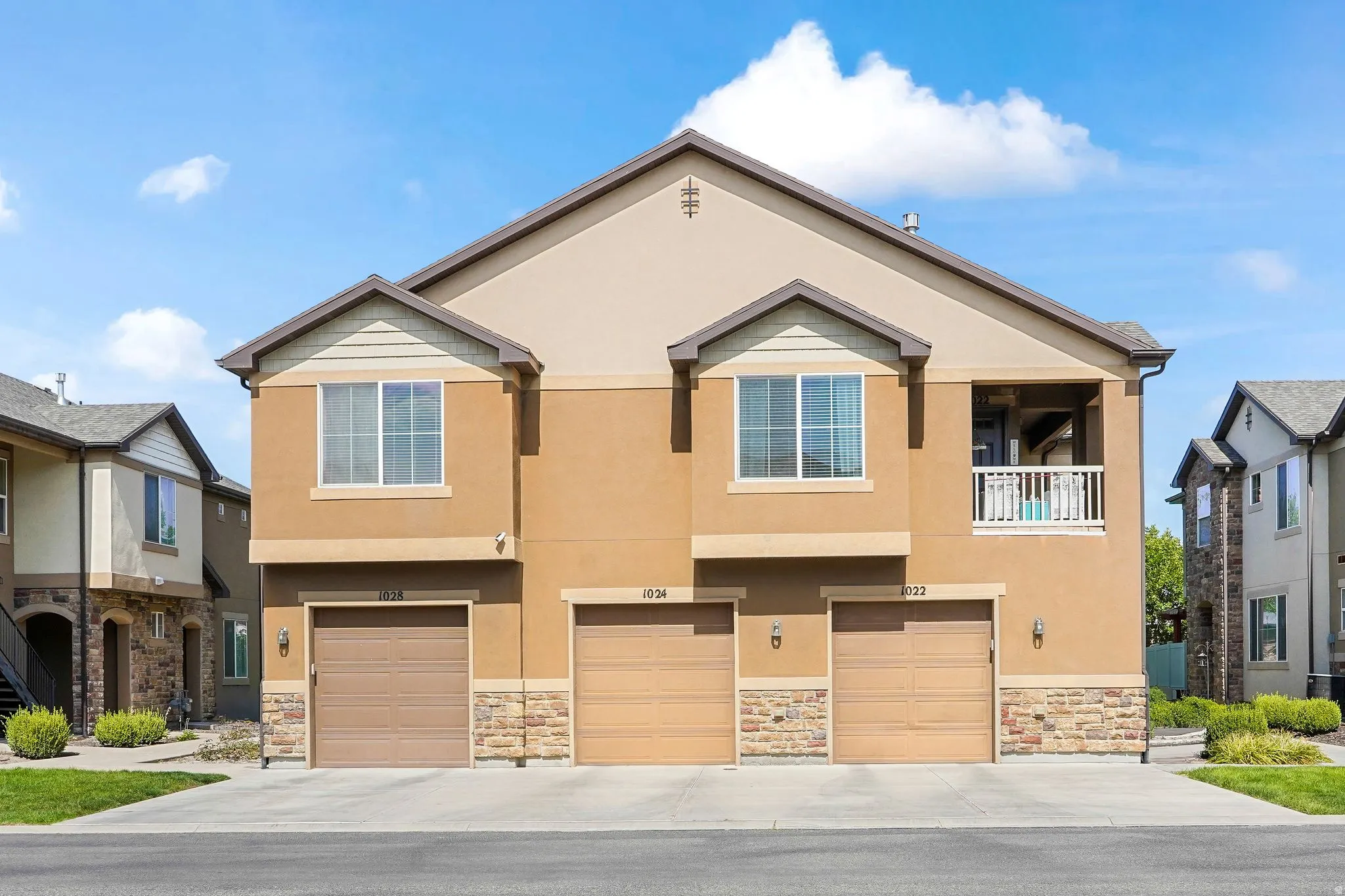Multi-story residential building with stucco and stone veneer facade