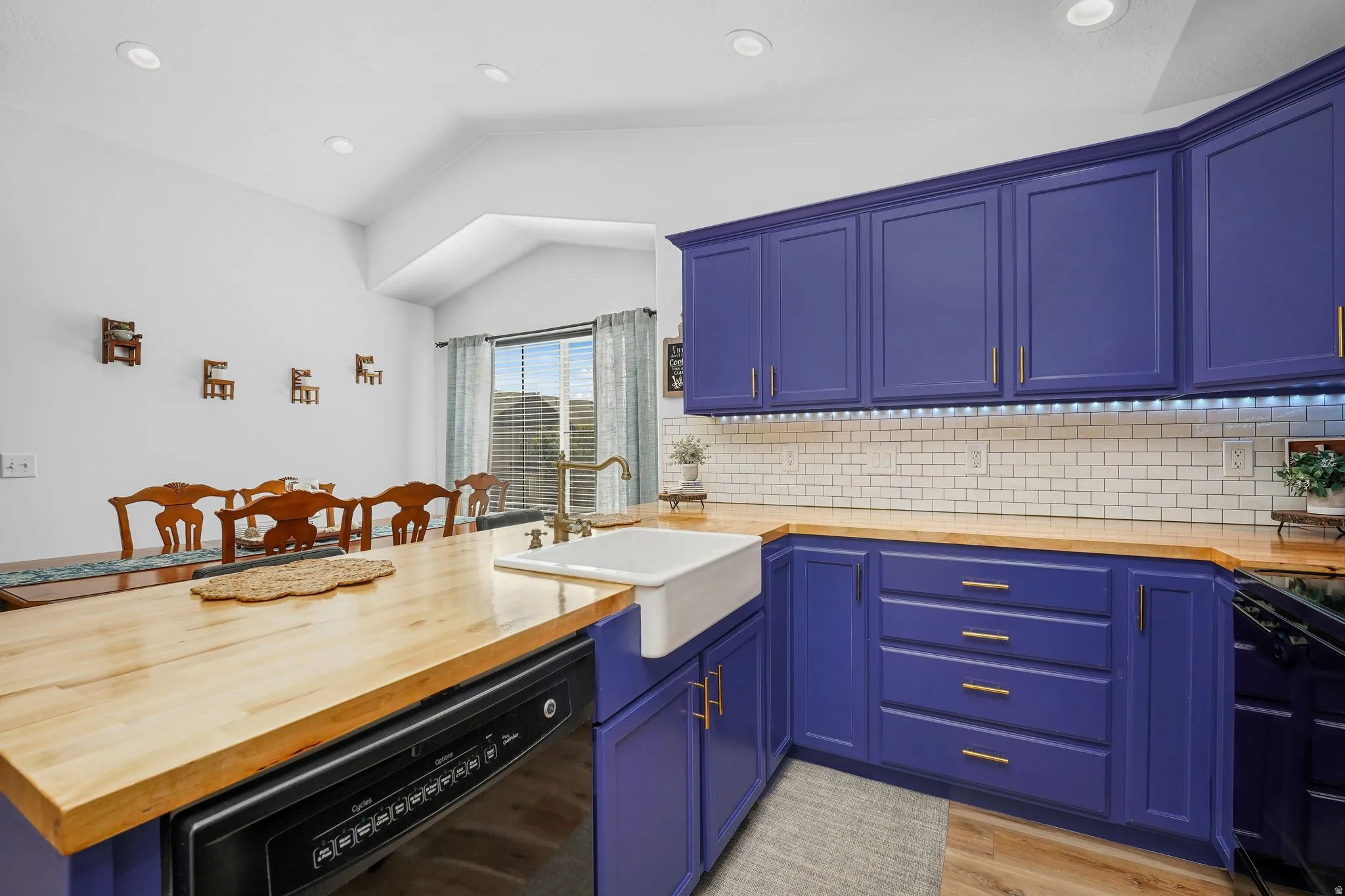 Updated kitchen with butcher block countertops, subway tile backsplash, farmhouse sink, modern lighting