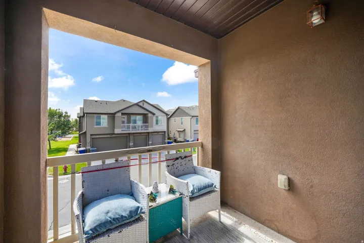 Outdoor balcony featuring a stucco exterior, a wood-paneled ceiling, and a mounted exterior light fixture