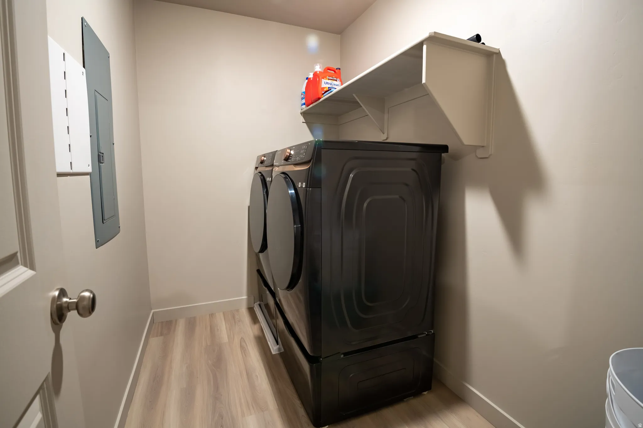 Dedicated utility space featuring light wood-finish flooring