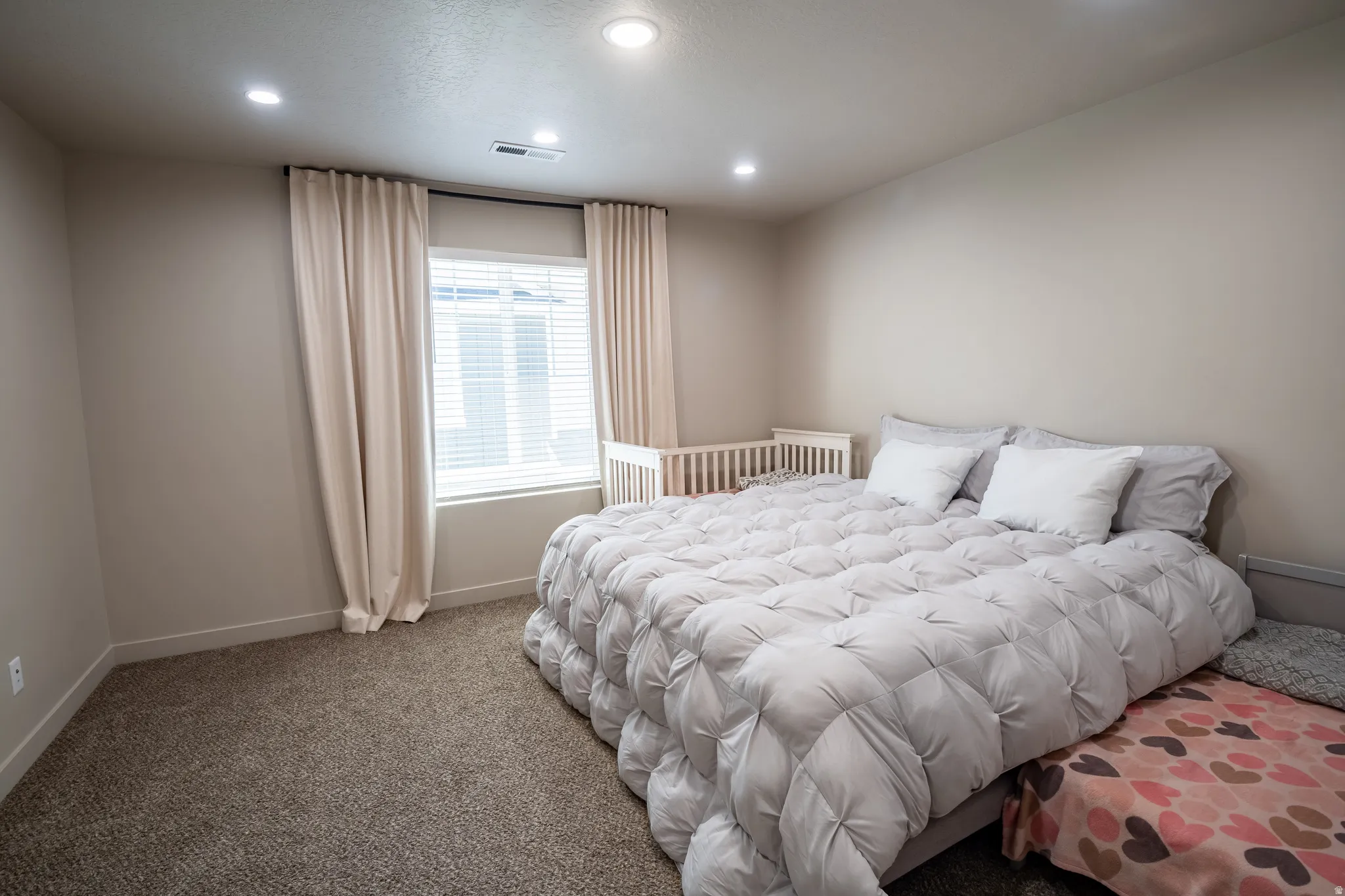 Recessed lighting illuminates neutral-toned walls and plush carpeting
