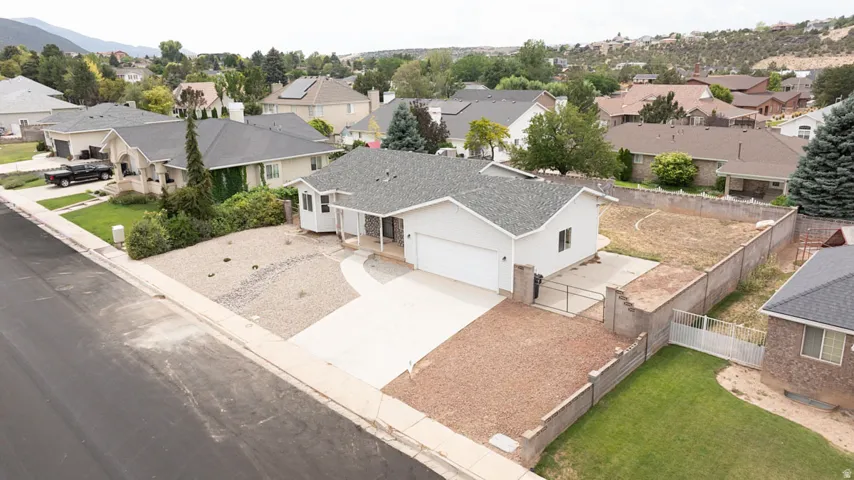 Single-story residence with an attached garage, paved driveway, and gravel landscaping