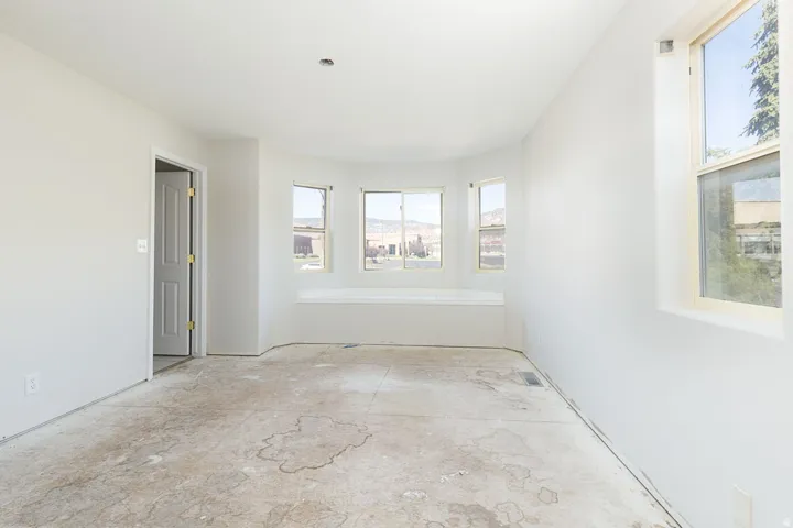 Bright room with a bay window featuring a built-in window seat, ample natural light, and a neutral color palette