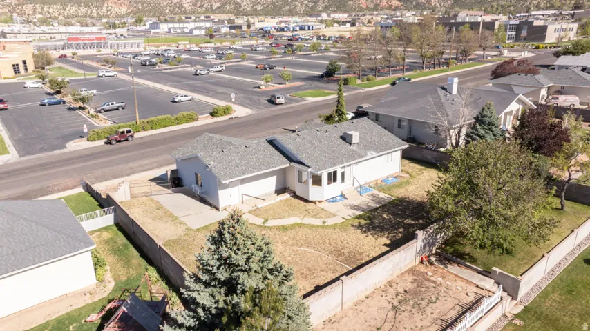 Ranch-style residence featuring a light-colored exterior and a gray shingle roof