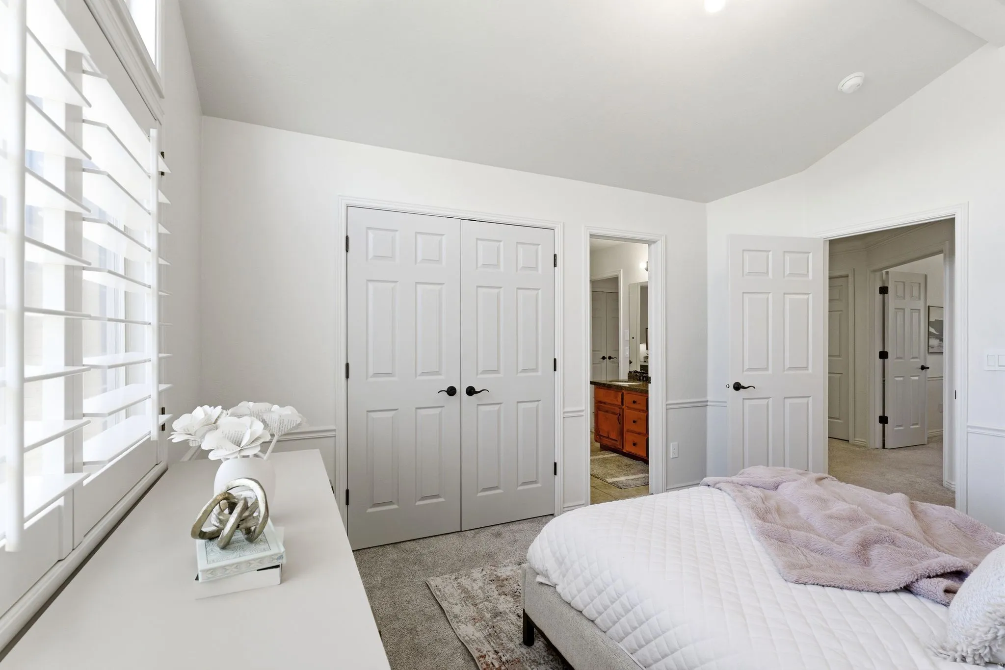 Bright interior space featuring white walls and a vaulted ceiling