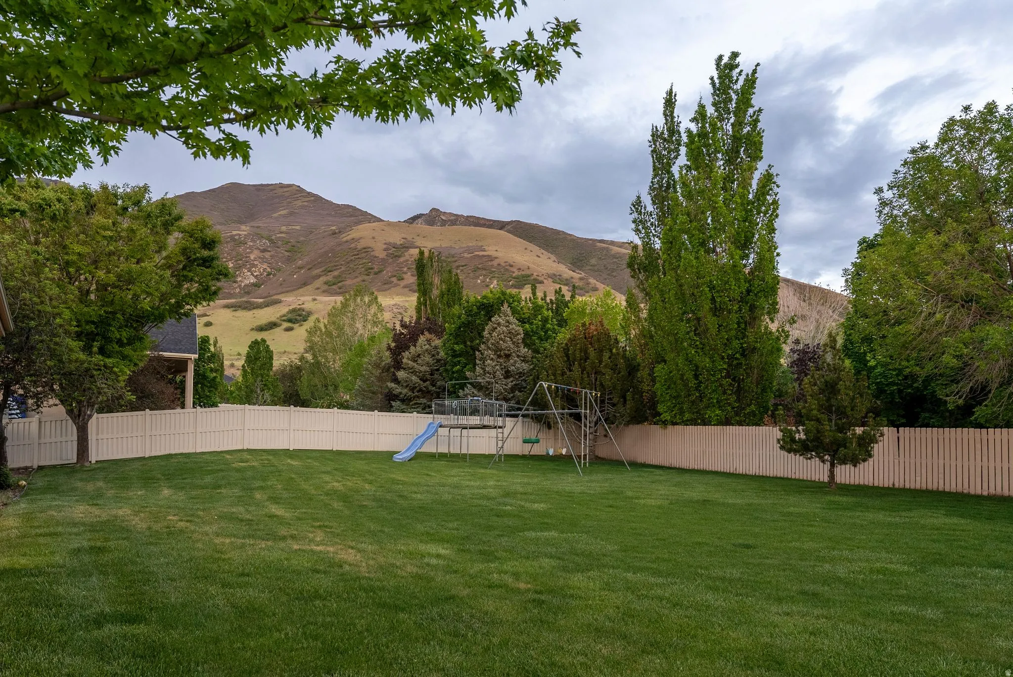 Expansive rear yard featuring a manicured lawn and complete perimeter fencing