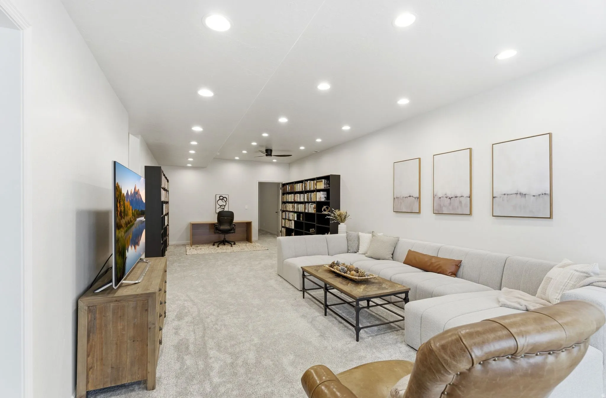 Expansive living area with recessed lighting, carpeted flooring, and built-in shelving
