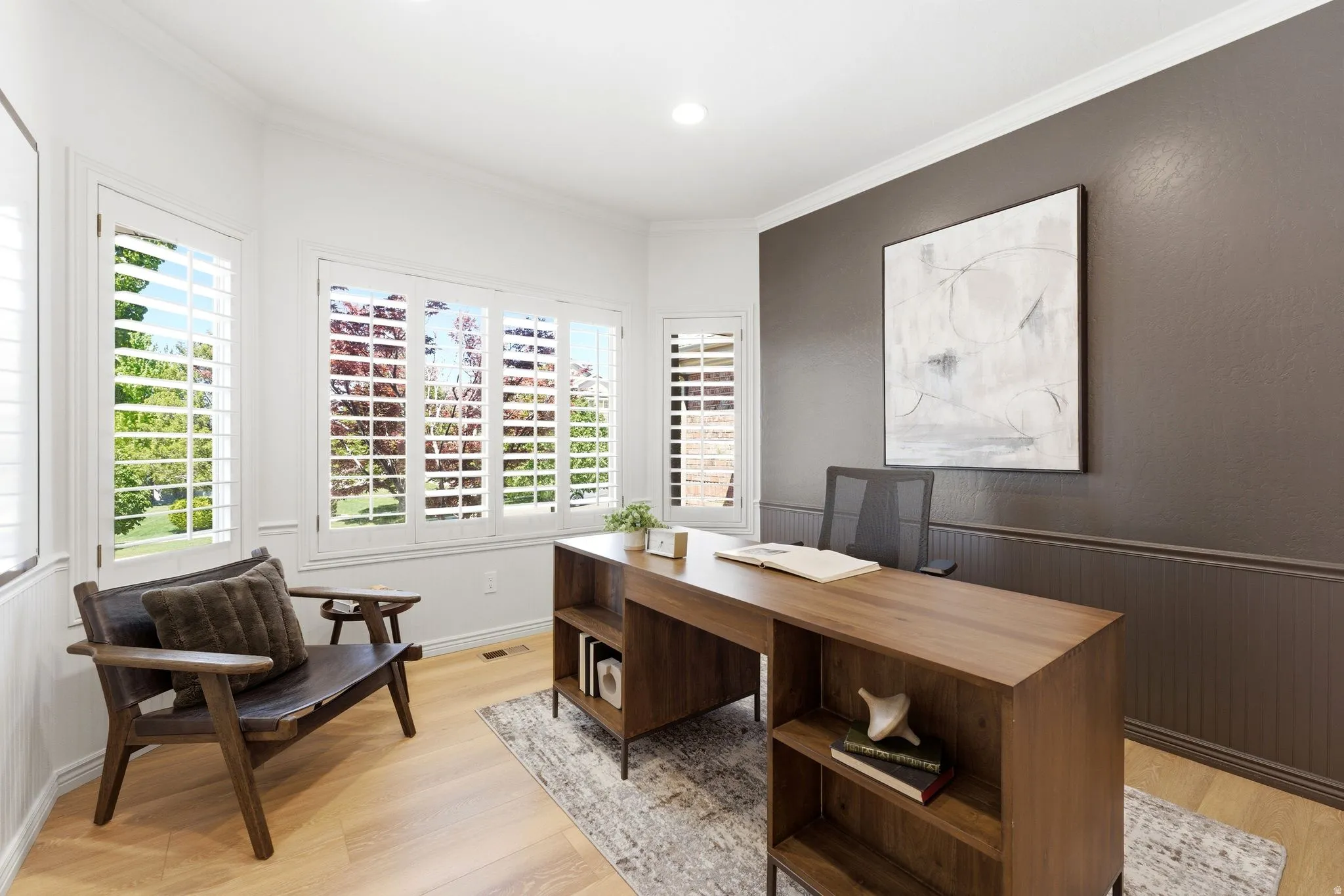 Bright interior space featuring a bay window with plantation shutters