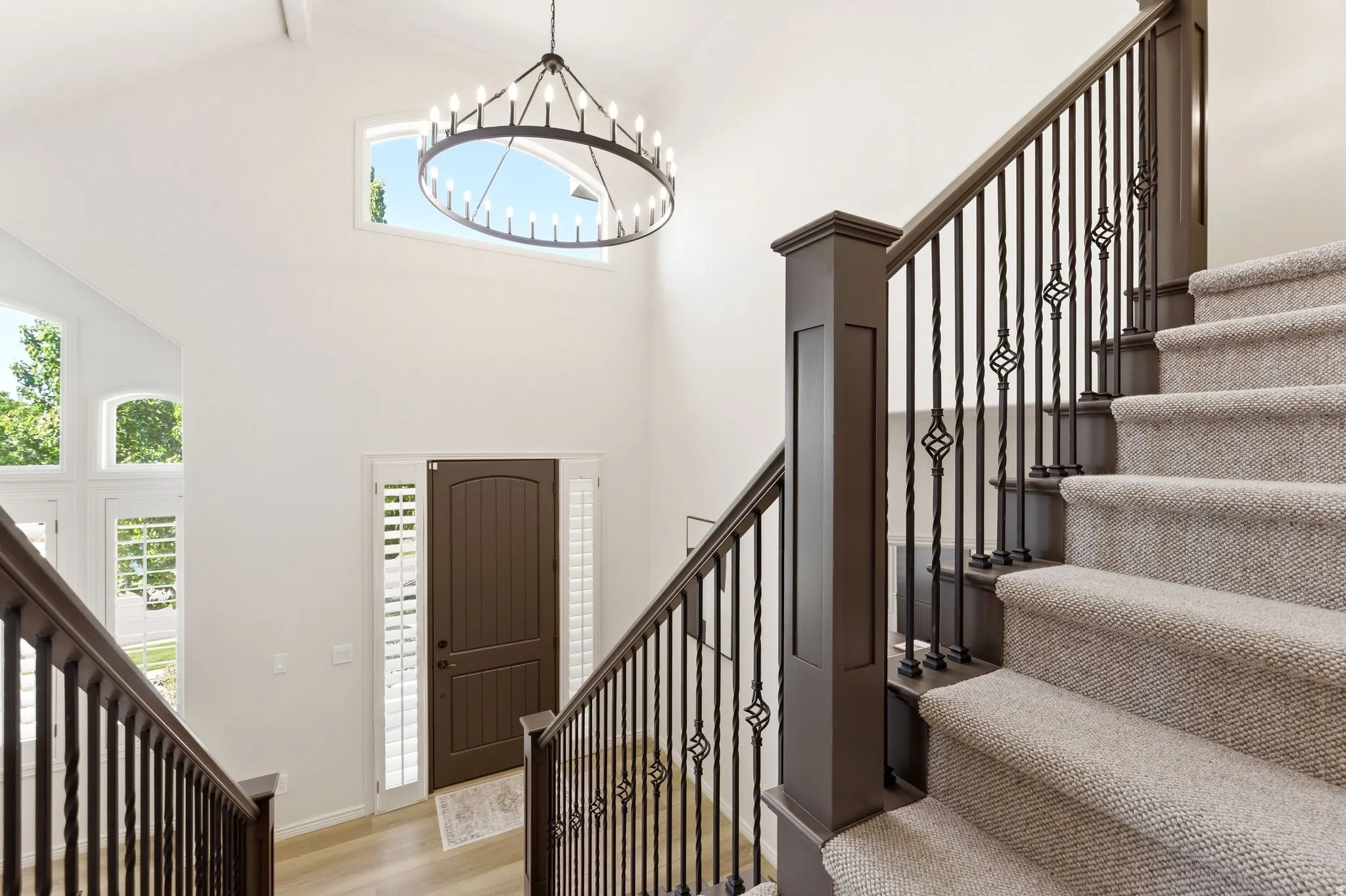 Grand entryway featuring a vaulted ceiling and a decorative chandelier