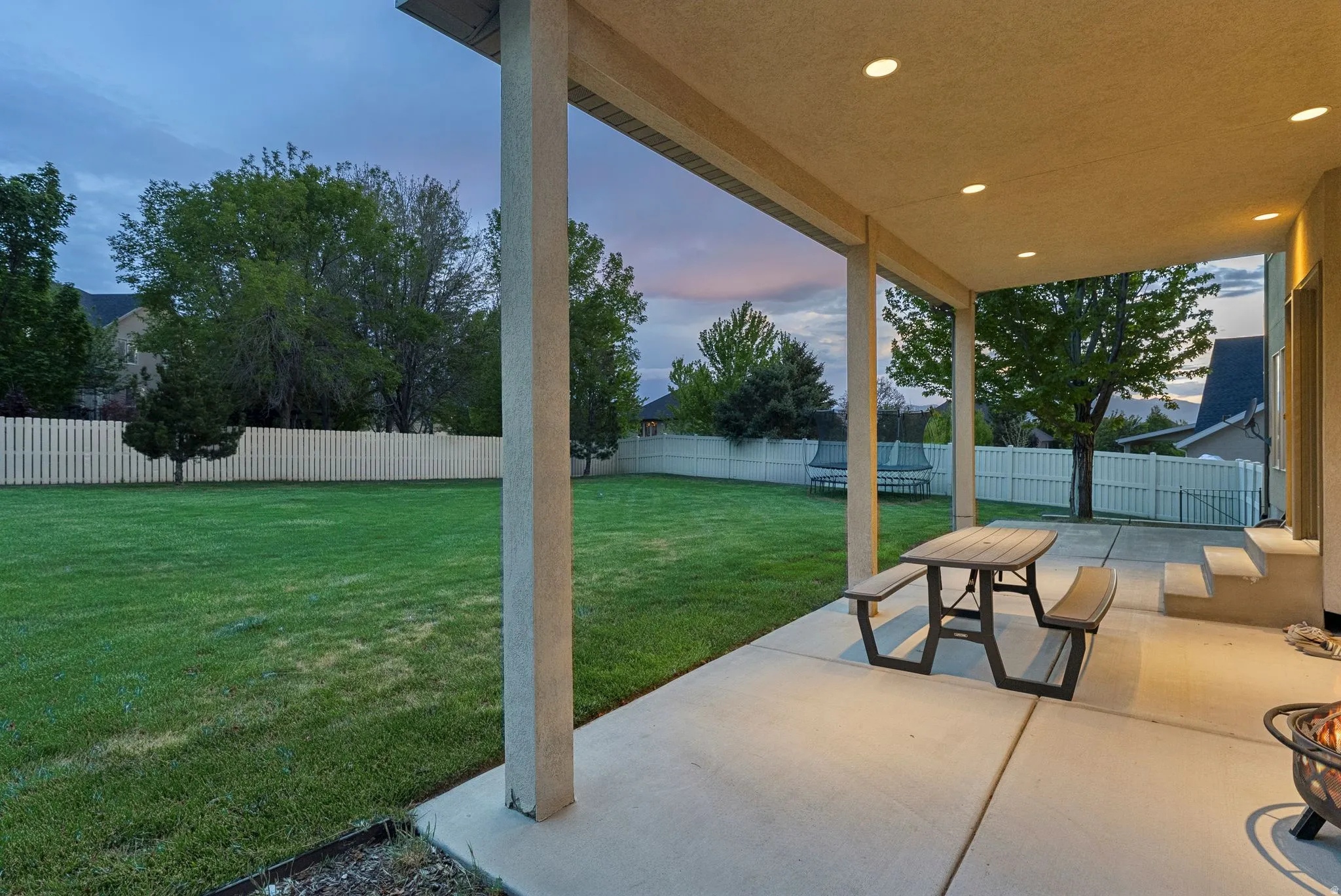 Covered patio featuring recessed lighting, concrete flooring, and direct access to a spacious lawn