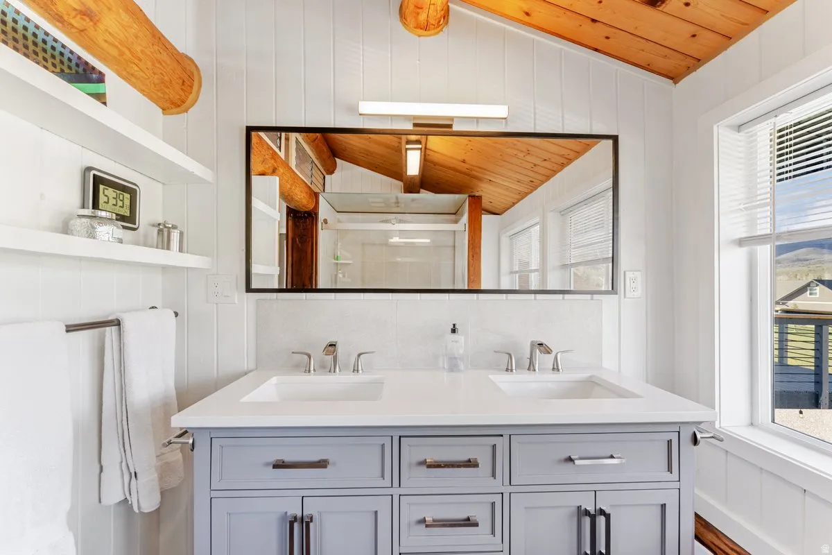 Bathroom featuring a dual-sink vanity with a light gray finish, white countertops, and brushed nickel hardware