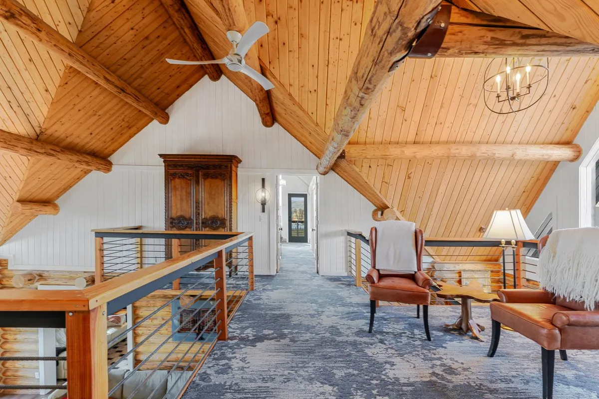 Vaulted wood-paneled ceiling featuring exposed log beams