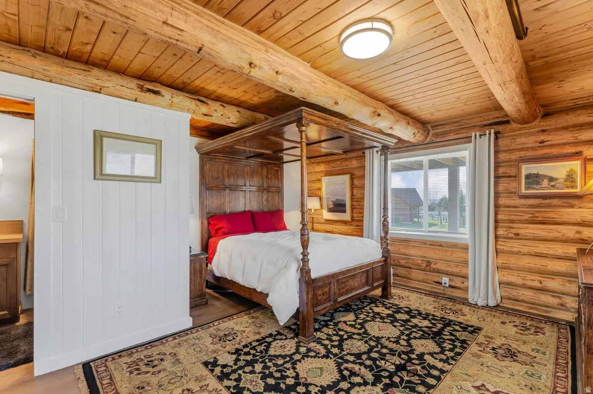 Room featuring extensive natural wood log walls and exposed log beam ceilings