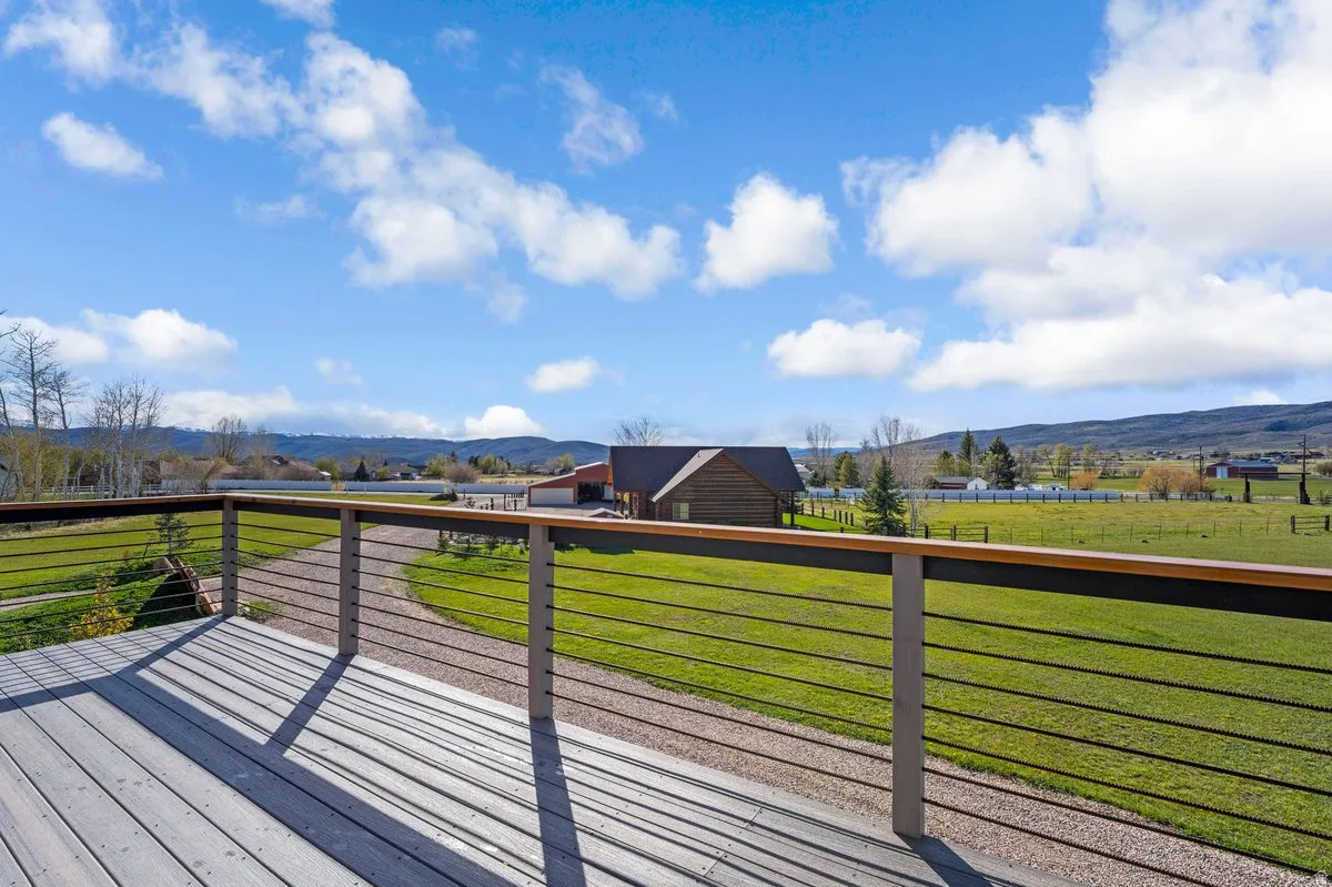 Expansive outdoor deck featuring wood-finish flooring and a contemporary cable railing system