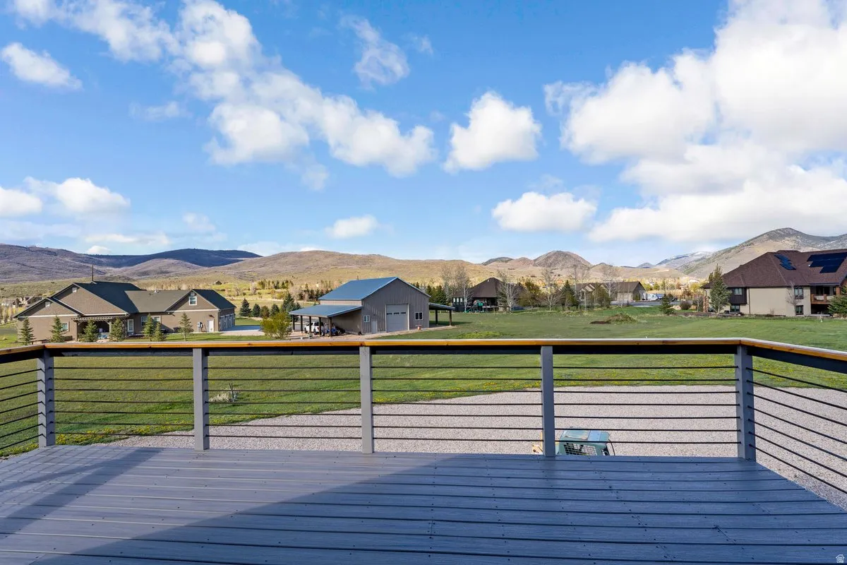 Expansive outdoor deck featuring wood-finish flooring and a cable railing system