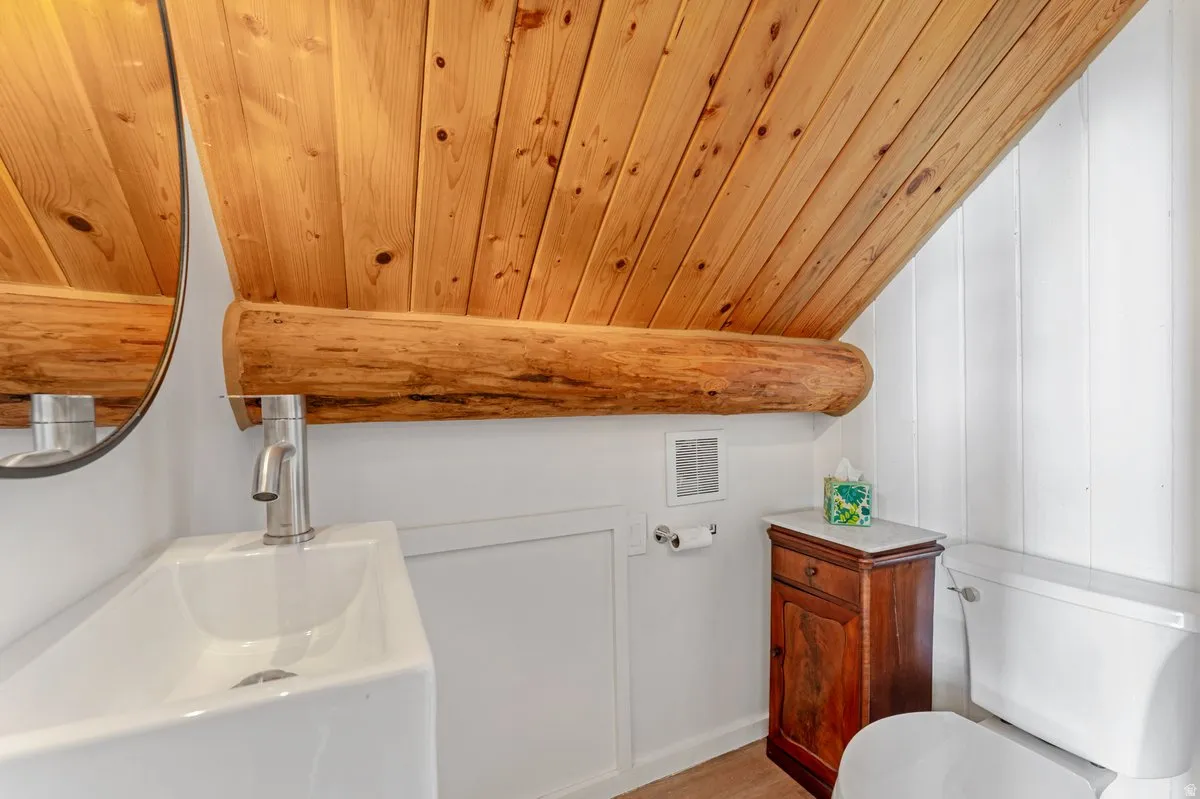 Sloping wood-paneled ceiling with an exposed log beam