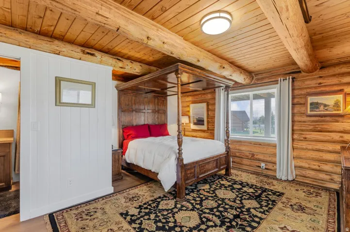 Room featuring extensive natural wood log walls and exposed log beam ceilings