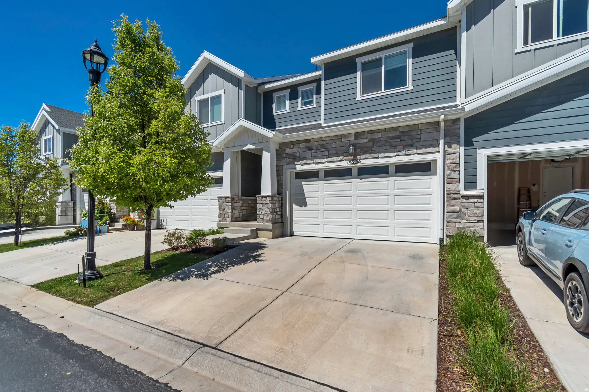 Contemporary townhouse exterior featuring blue horizontal siding and stone accents