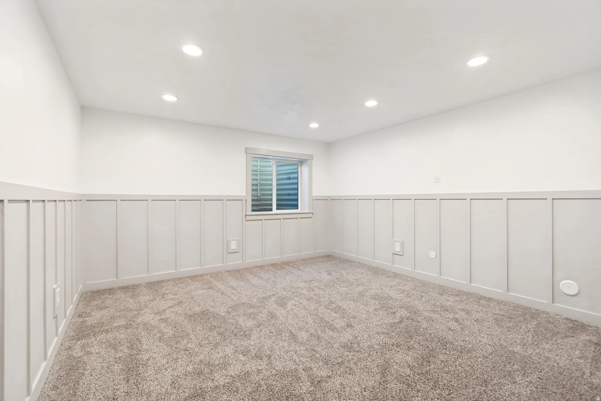 Room featuring neutral-toned carpeting, recessed ceiling lighting, and a white-framed window