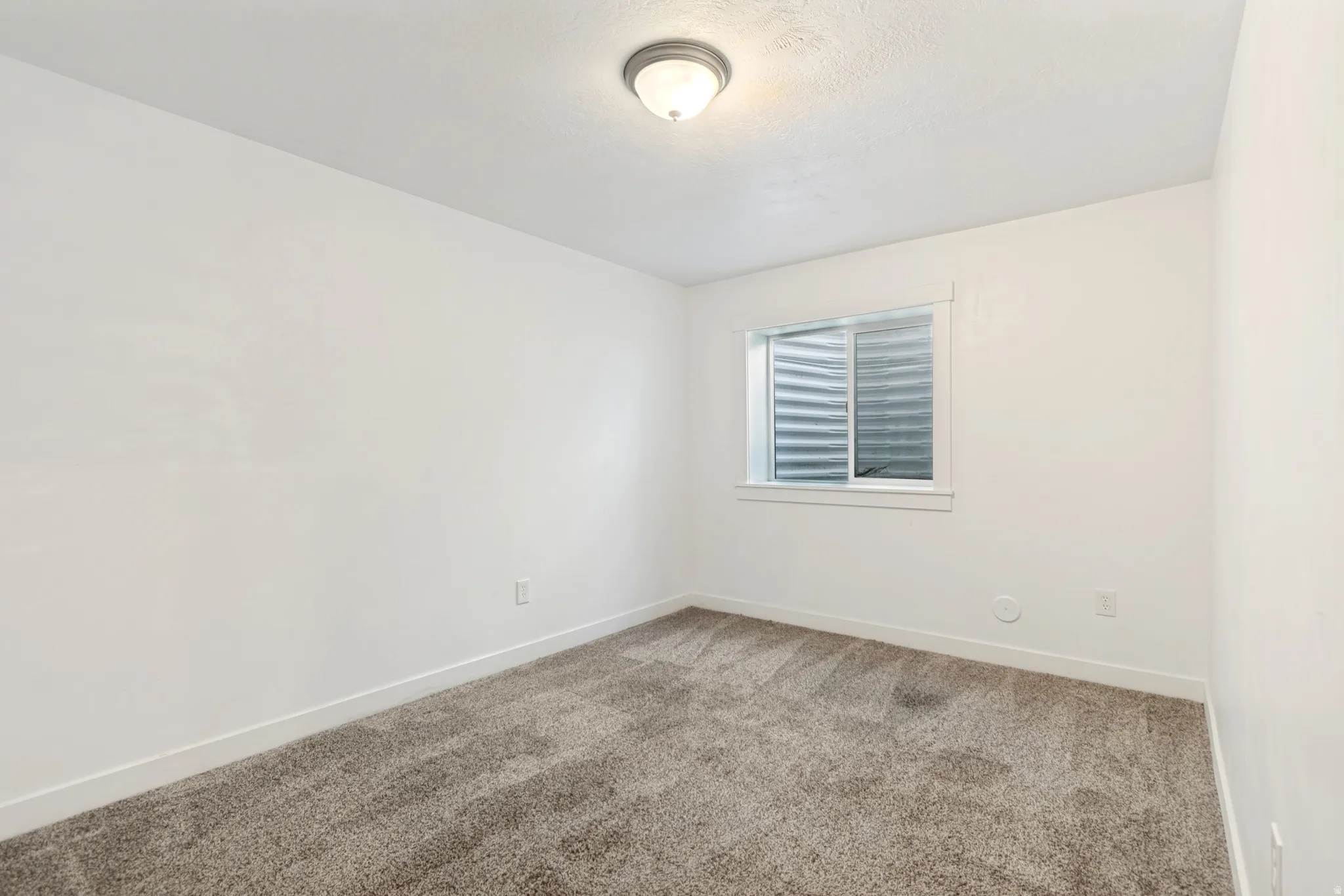 Neutral-toned wall-to-wall carpeting complements the white walls and trim