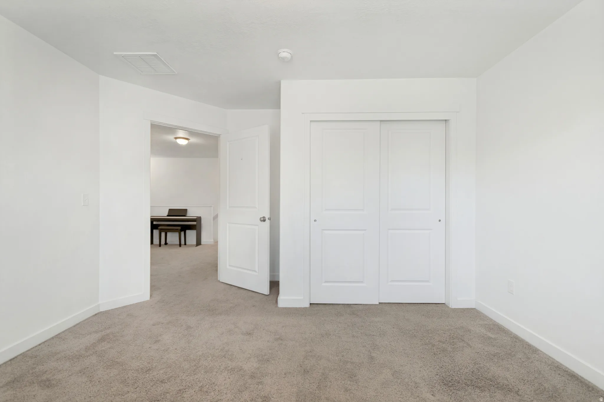 Neutral tone carpet flooring and white painted walls create a versatile interior