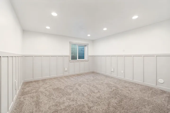 Room featuring neutral-toned carpeting, recessed ceiling lighting, and a white-framed window
