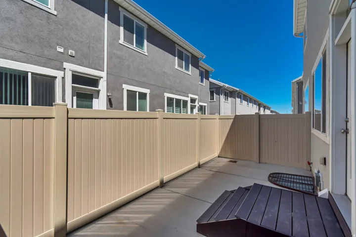 Private patio area featuring concrete flooring and light-toned privacy fencing