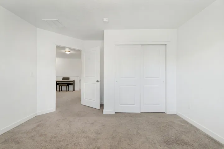 Neutral tone carpet flooring and white painted walls create a versatile interior