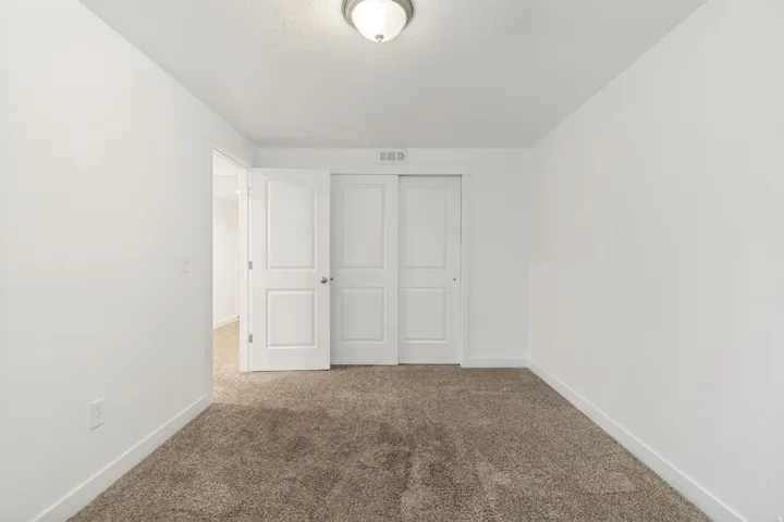 Neutral-toned carpeting extends throughout this room, complemented by white walls and trim