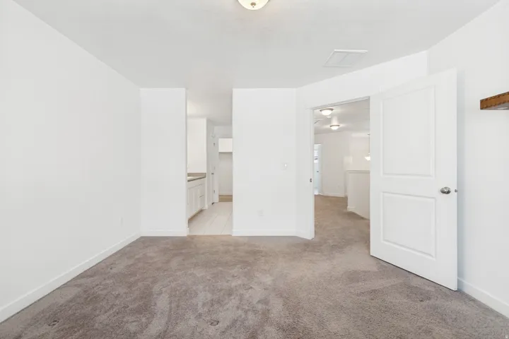 Carpeted room with white walls, baseboards, and a ceiling-mounted light fixture