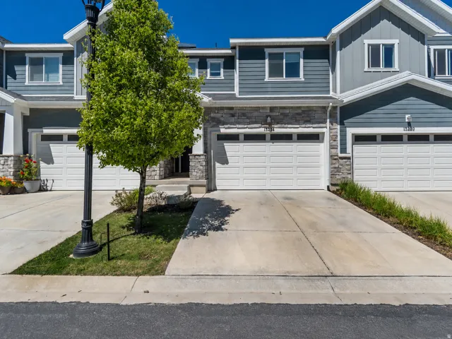 Contemporary townhouse exterior featuring blue siding, white trim, and stone accents