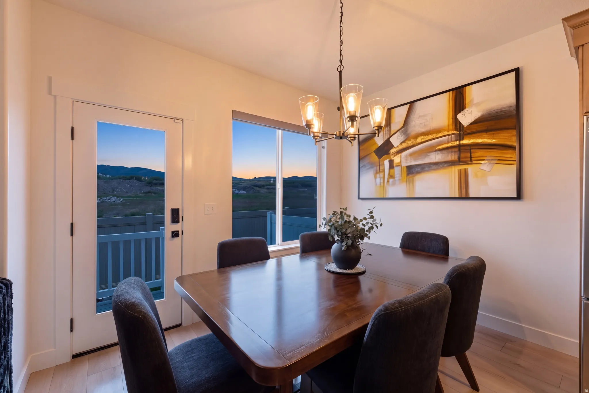 Dining area featuring a wood-finish table, a decorative chandelier, and light wood-finish flooring