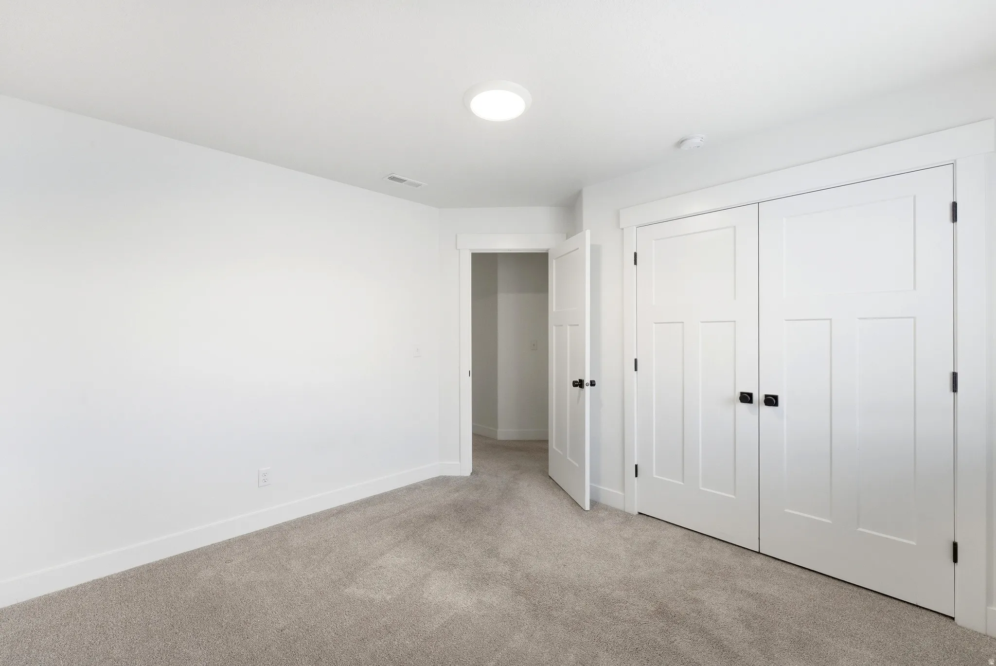 Bedroom featuring neutral carpeting and white painted walls