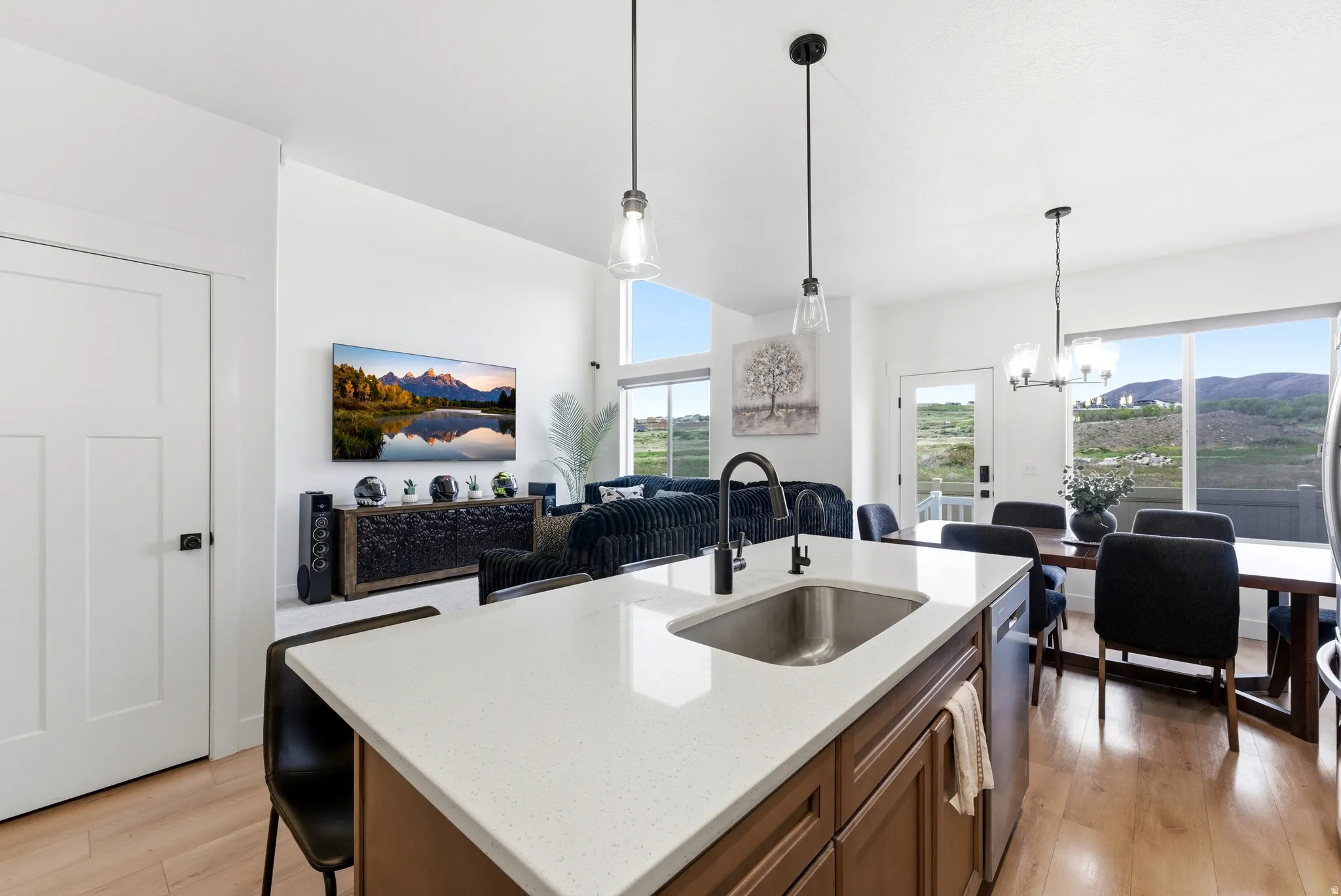 Kitchen island with a stainless steel sink, dark faucet, and light countertop