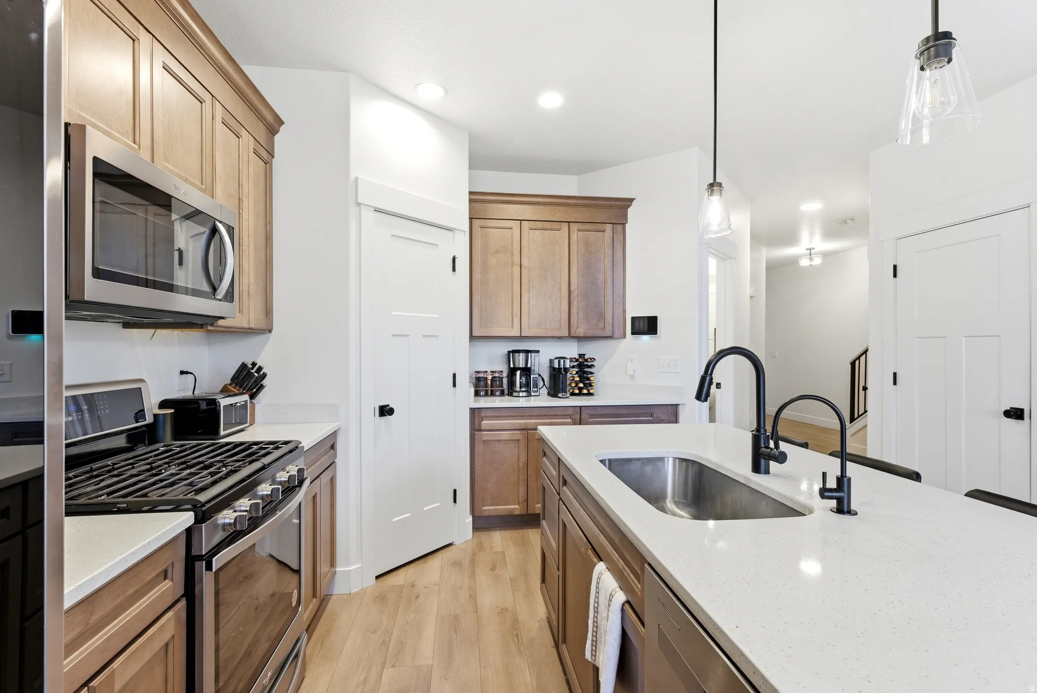 Kitchen island featuring a stainless steel undermount sink and matte black faucet