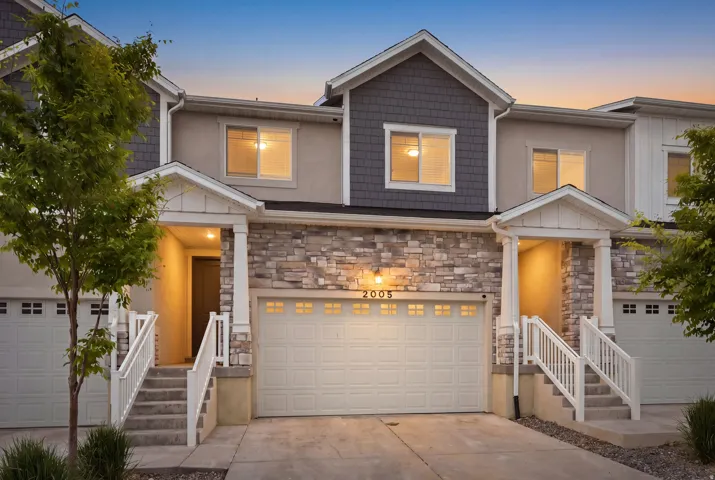 Multi-level townhome exterior featuring stone veneer and shingle siding accents