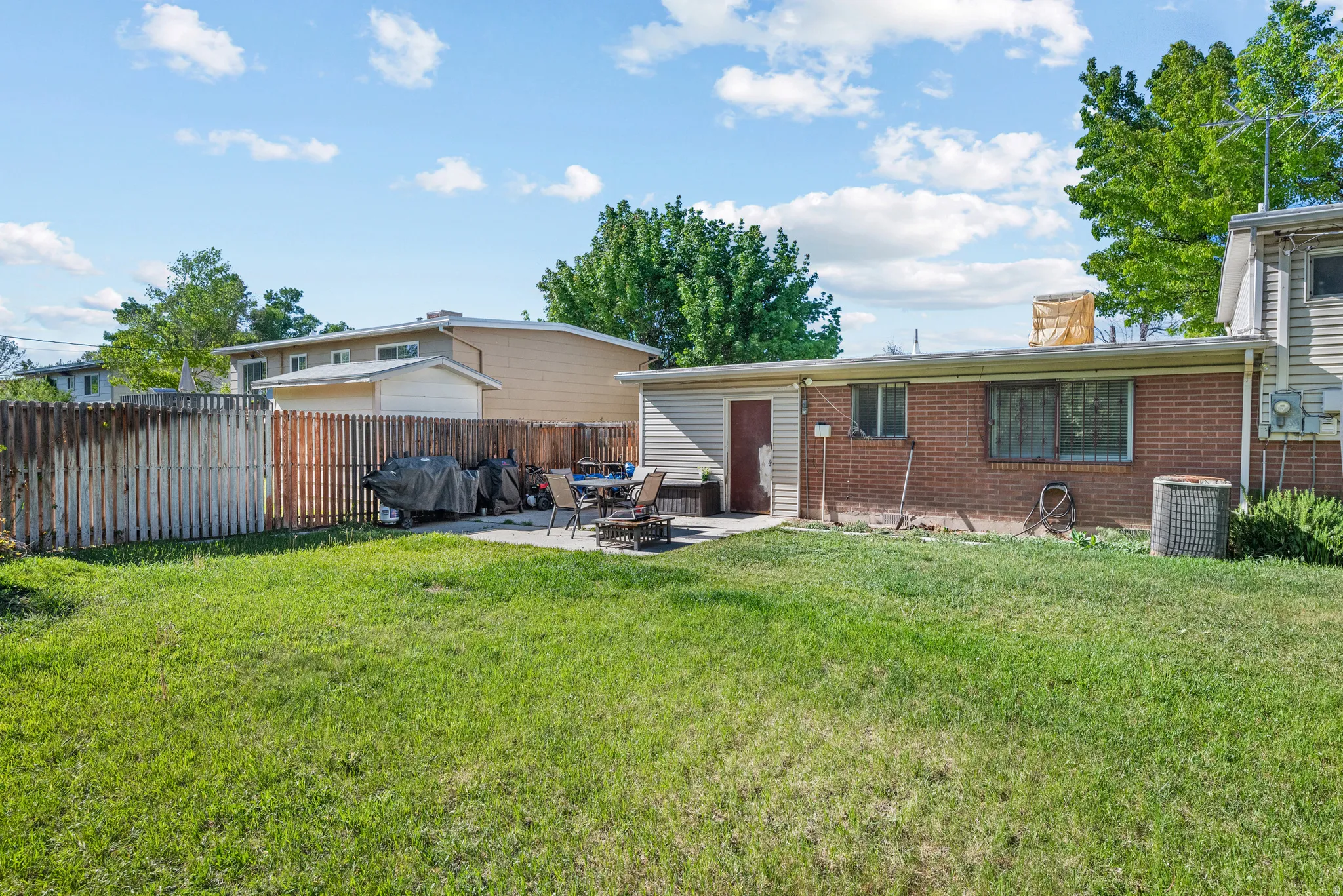 Expansive grass lawn with a concrete patio