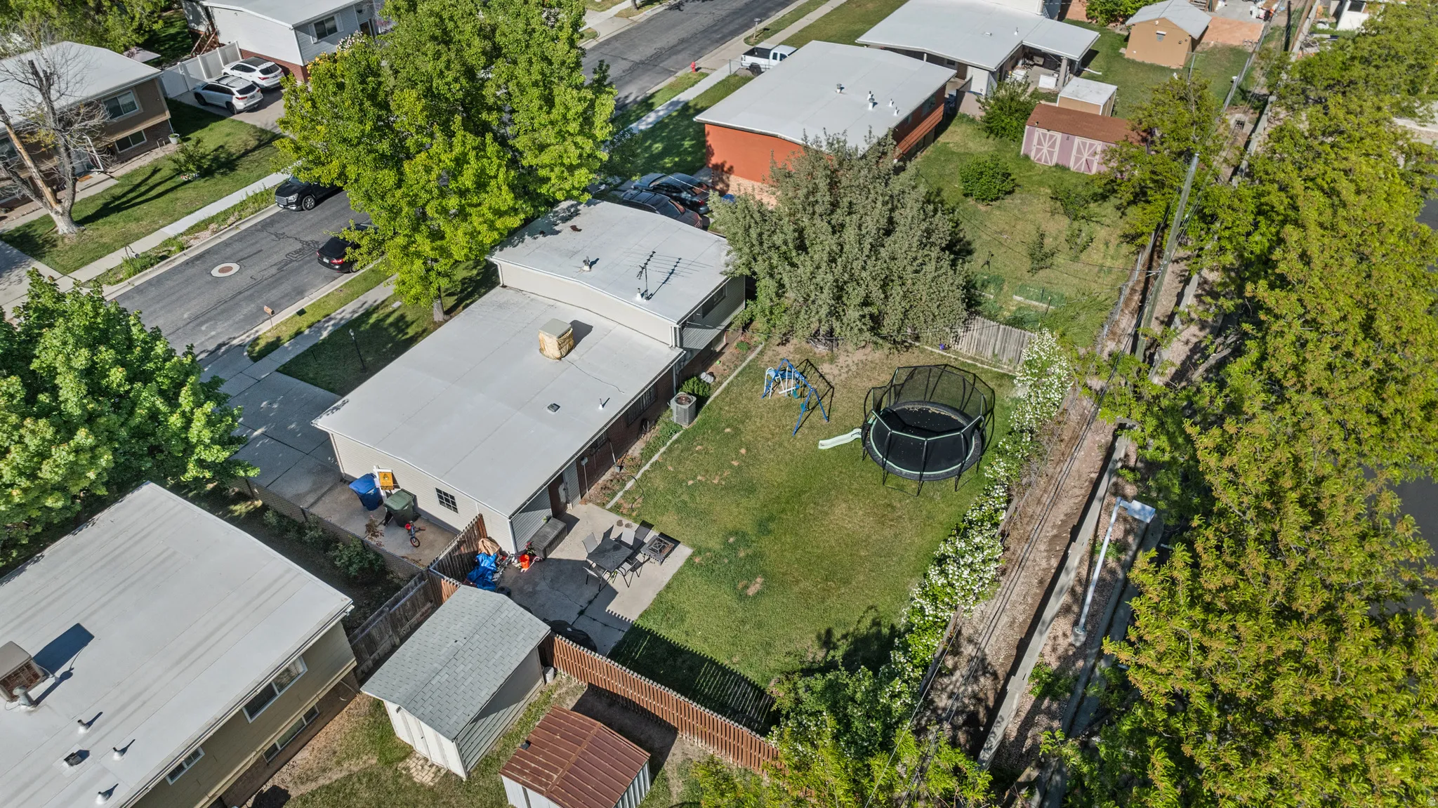 Expansive backyard featuring a manicured lawn, established landscaping, and a fenced perimeter