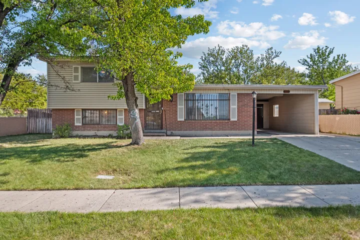 Split-level residence featuring a brick facade and tan siding