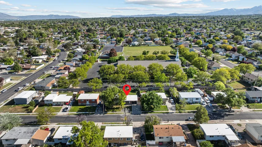 Overhead view of a residential neighborhood featuring established trees, paved streets, and single-story properties