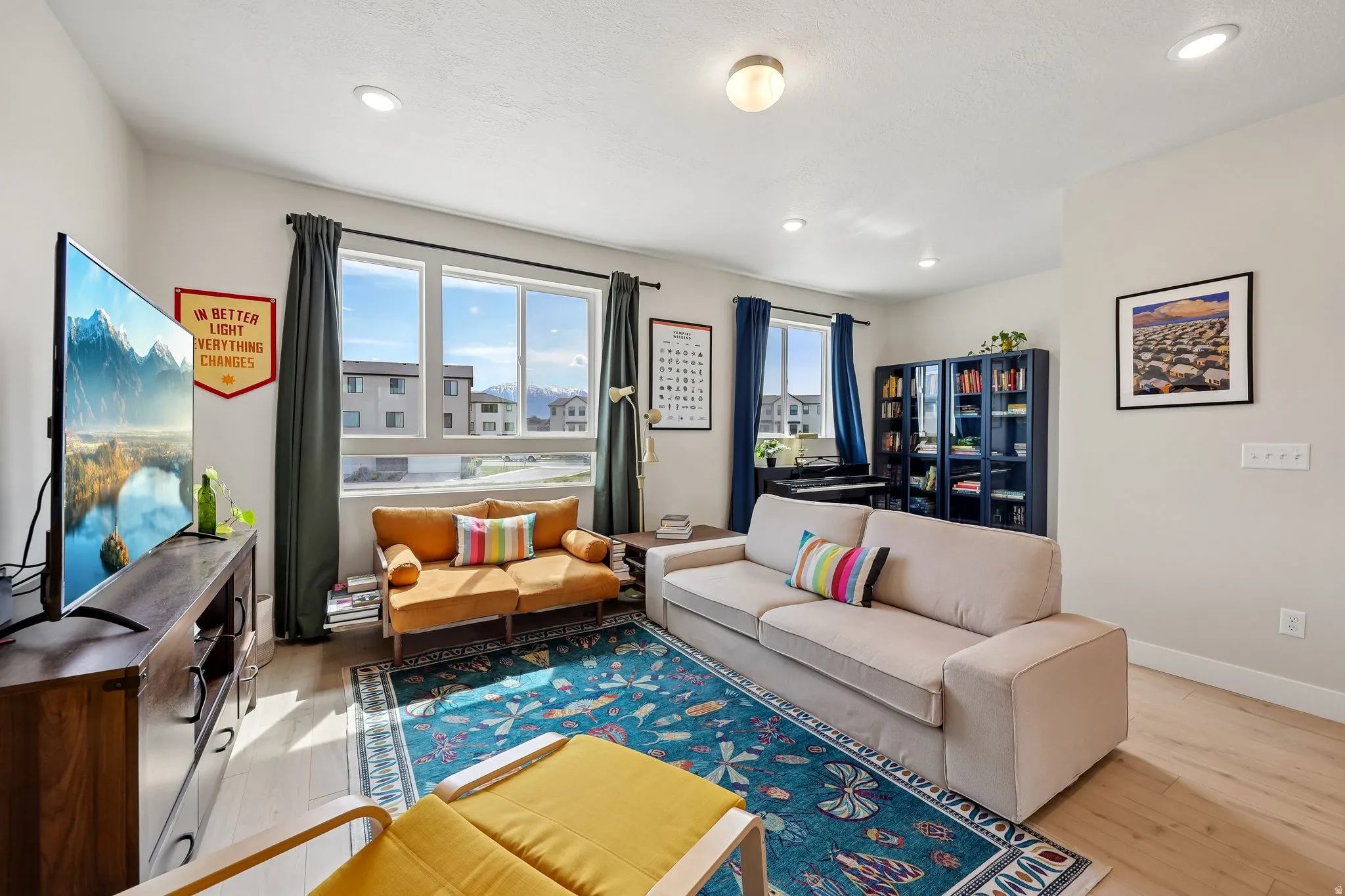 Living room with light wood-style flooring and recessed lighting