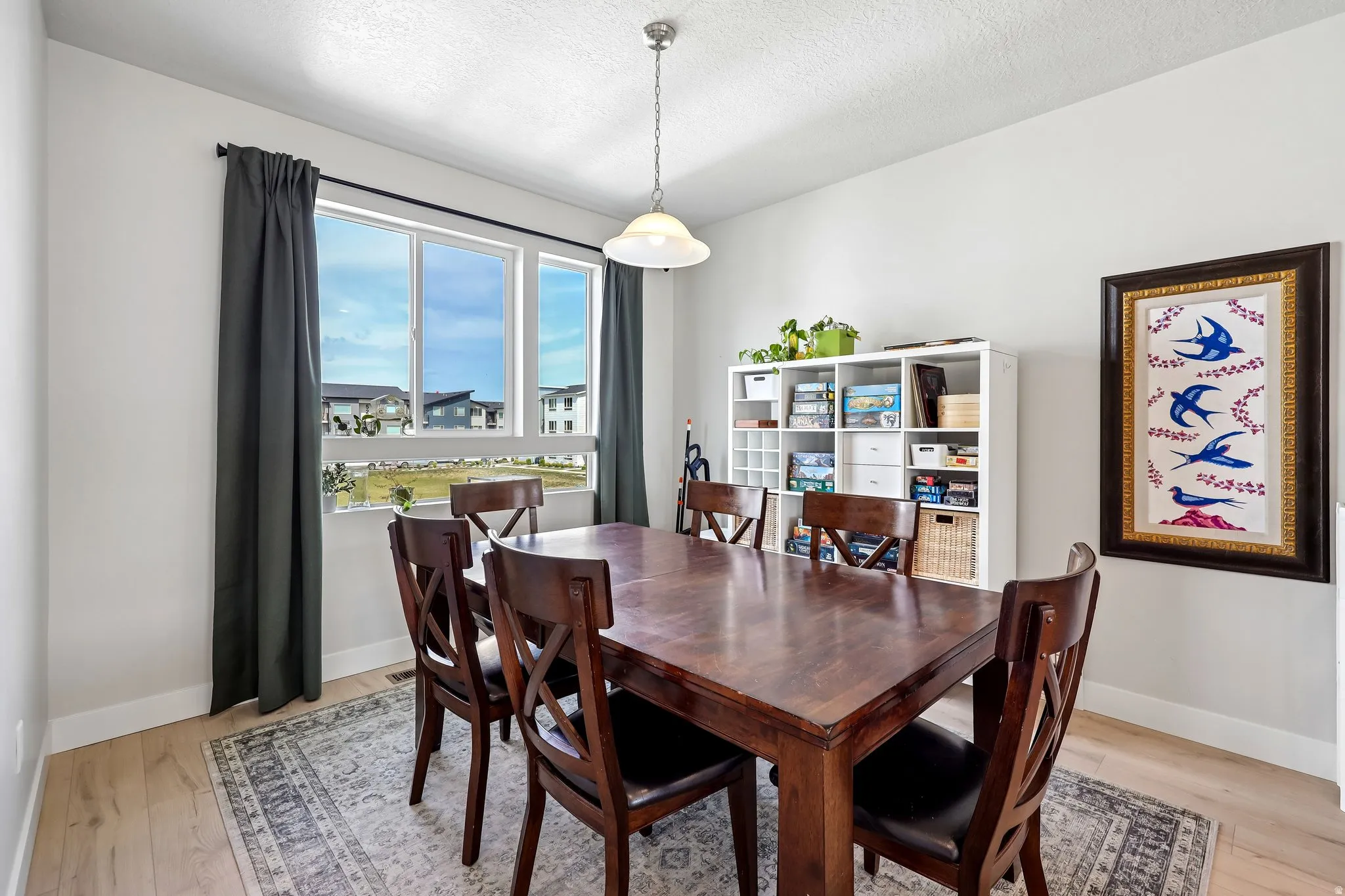 Dining space with light wood finished floors and a textured ceiling
