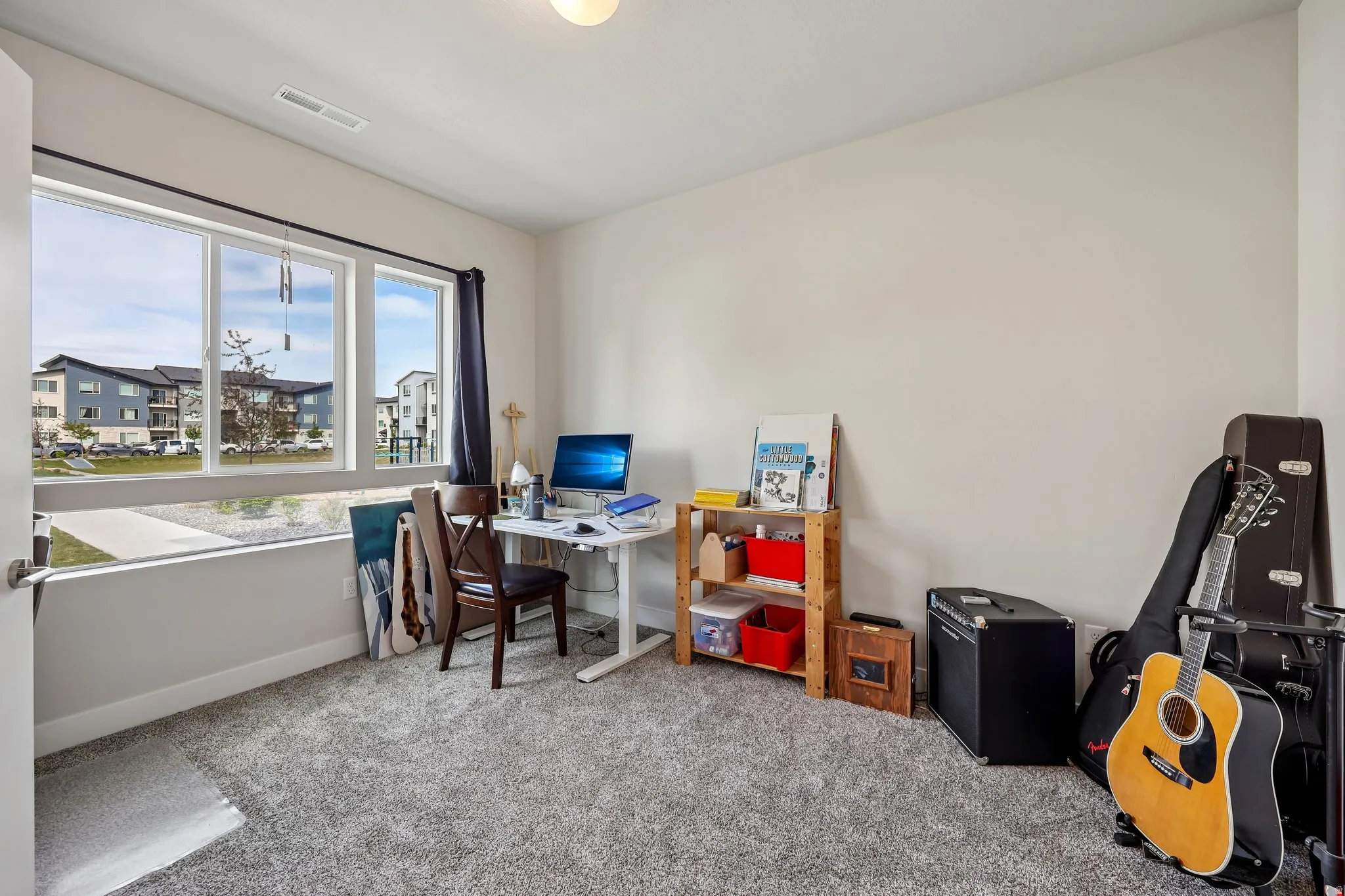 Home office with light colored carpet and baseboards