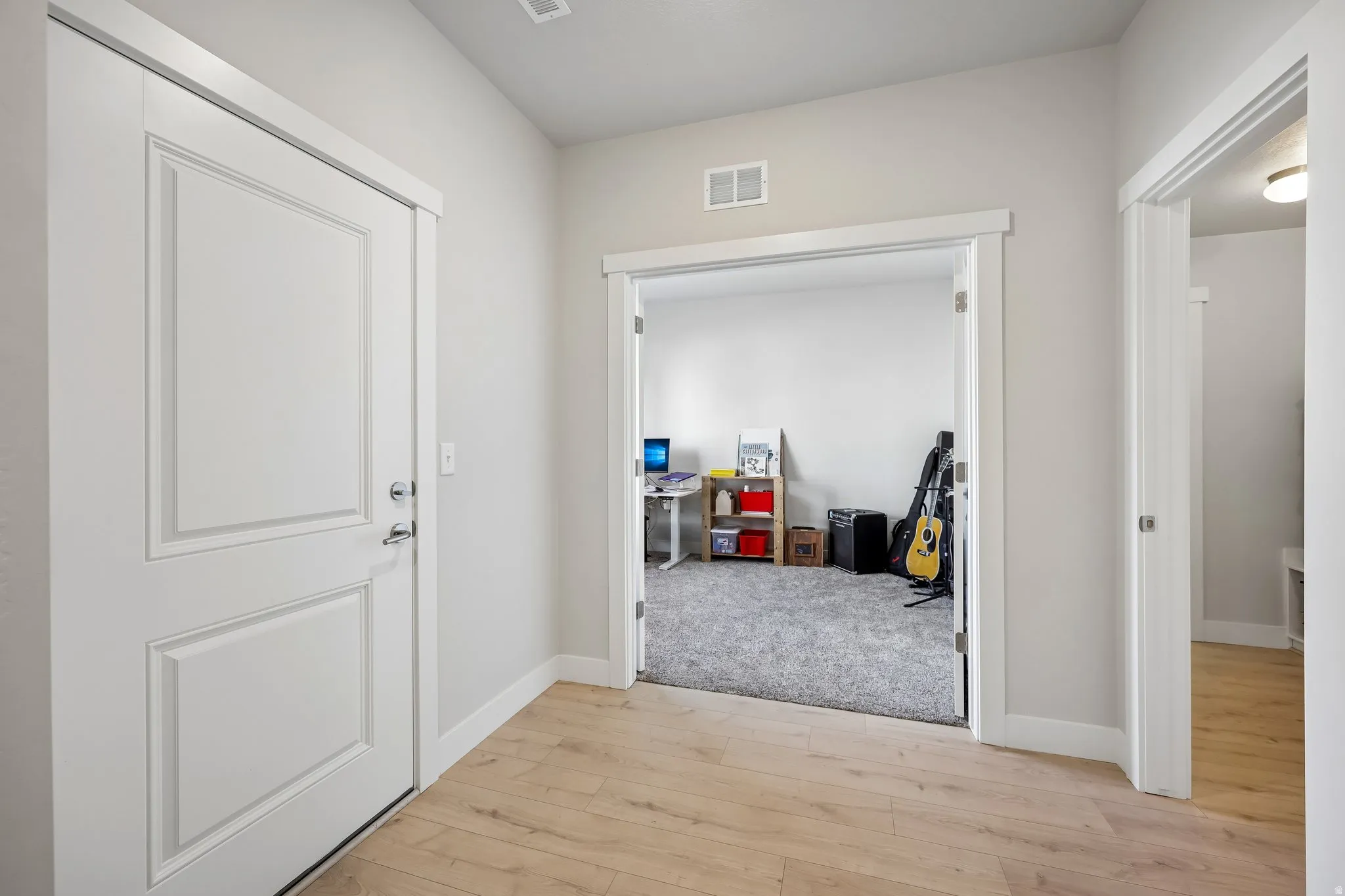 Corridor featuring light wood-style floors and baseboards