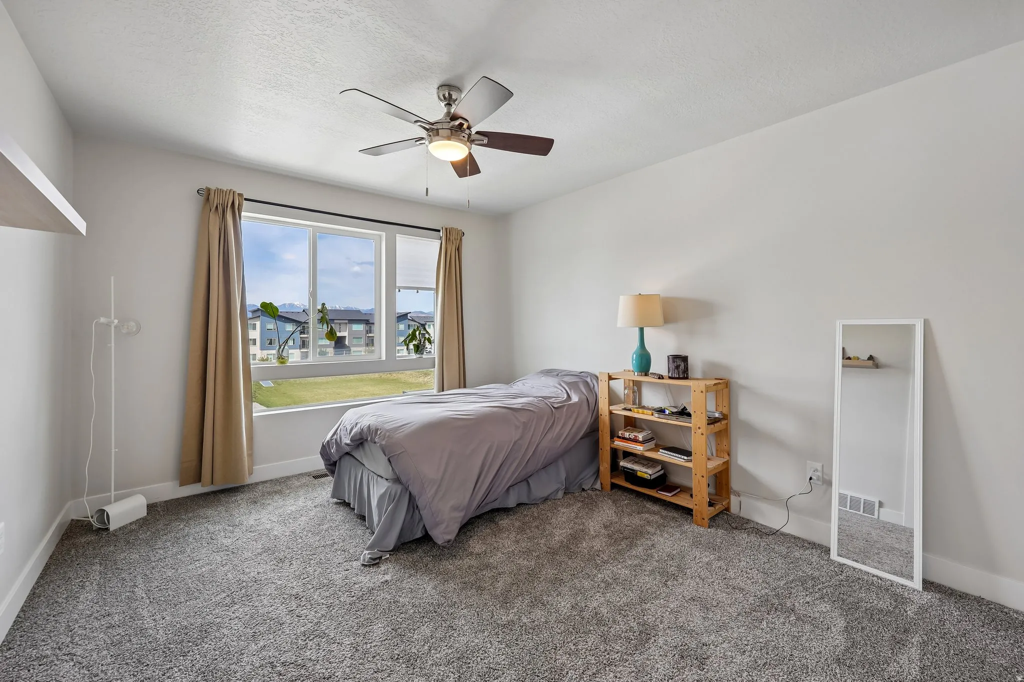 Bedroom featuring dark carpet, ceiling fan, and a textured ceiling